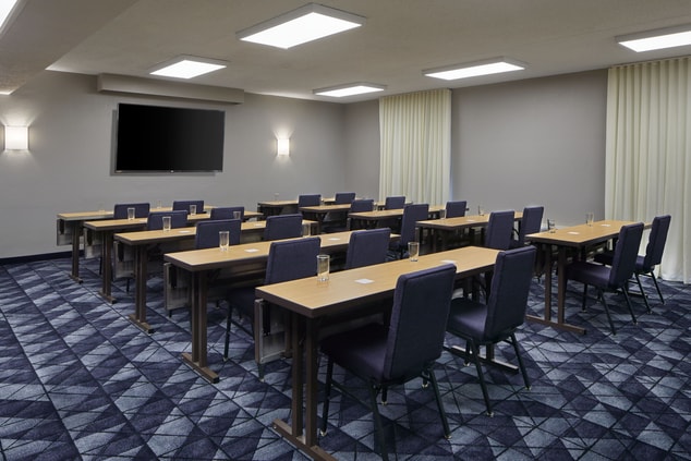 Spacious meeting space with TV and business set up