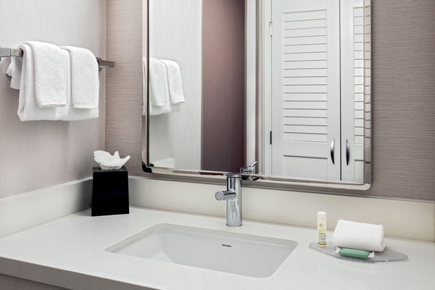 Bathroom vanity with fresh towels, tissues, etc.