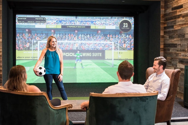 Group of people by  soccer Topgolf game simulator
