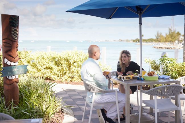Couple eats dinner at a table by the ocean