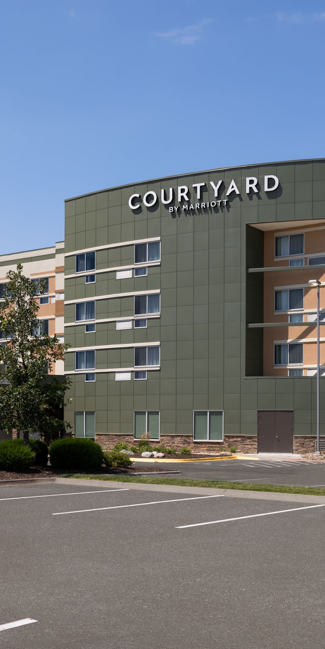 Exterior of hotel with parking log at daytime