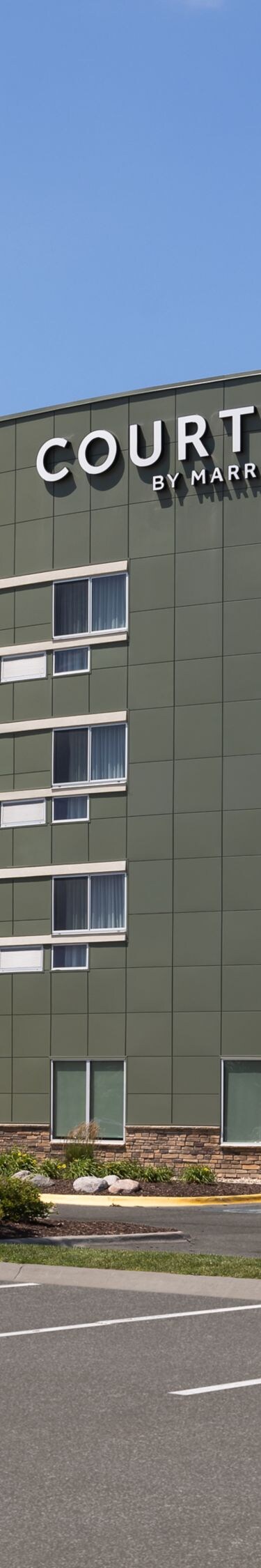 Exterior of hotel with parking log at daytime