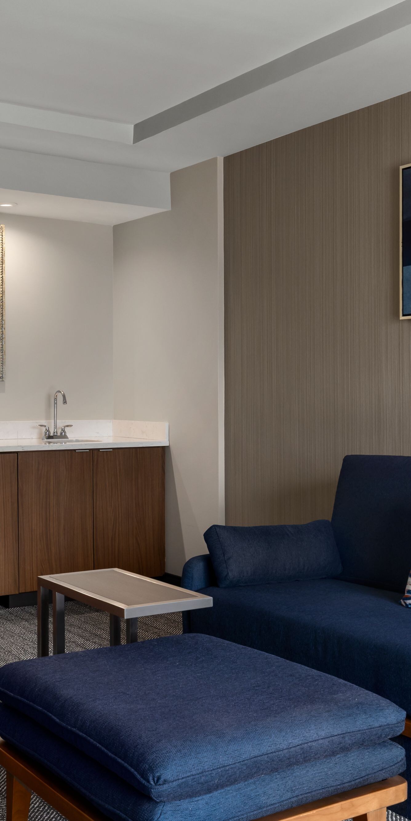 Suite living area with blue sofa and wet bar