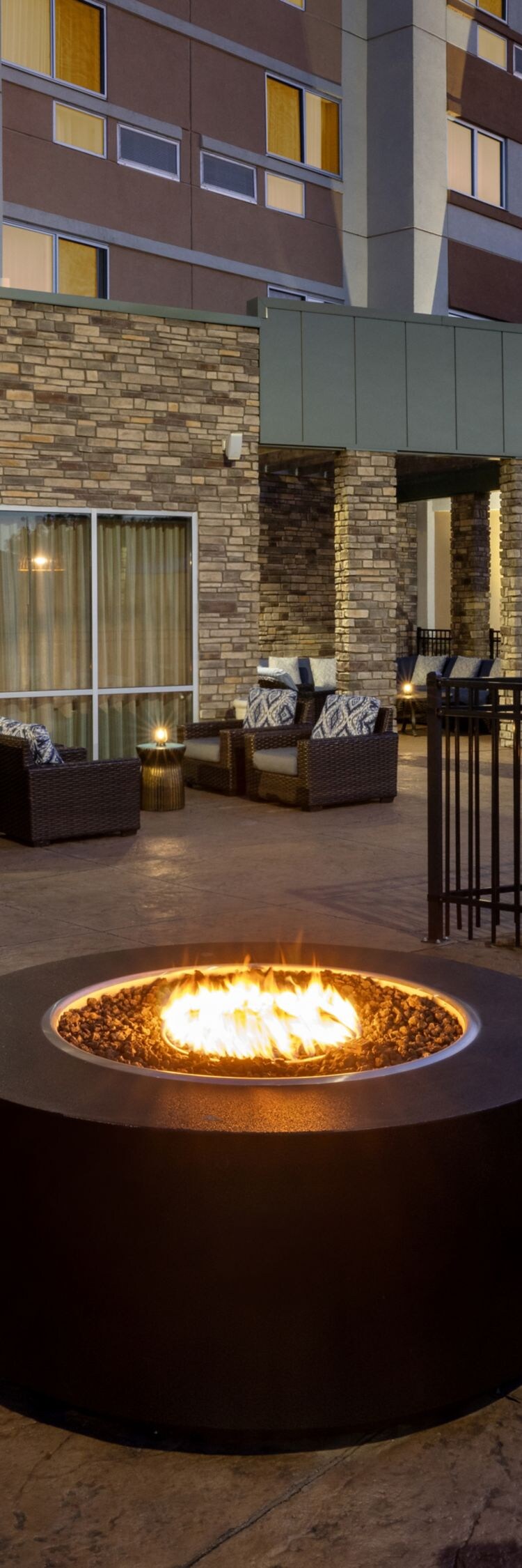firepit and curved sofas on patio at dusk