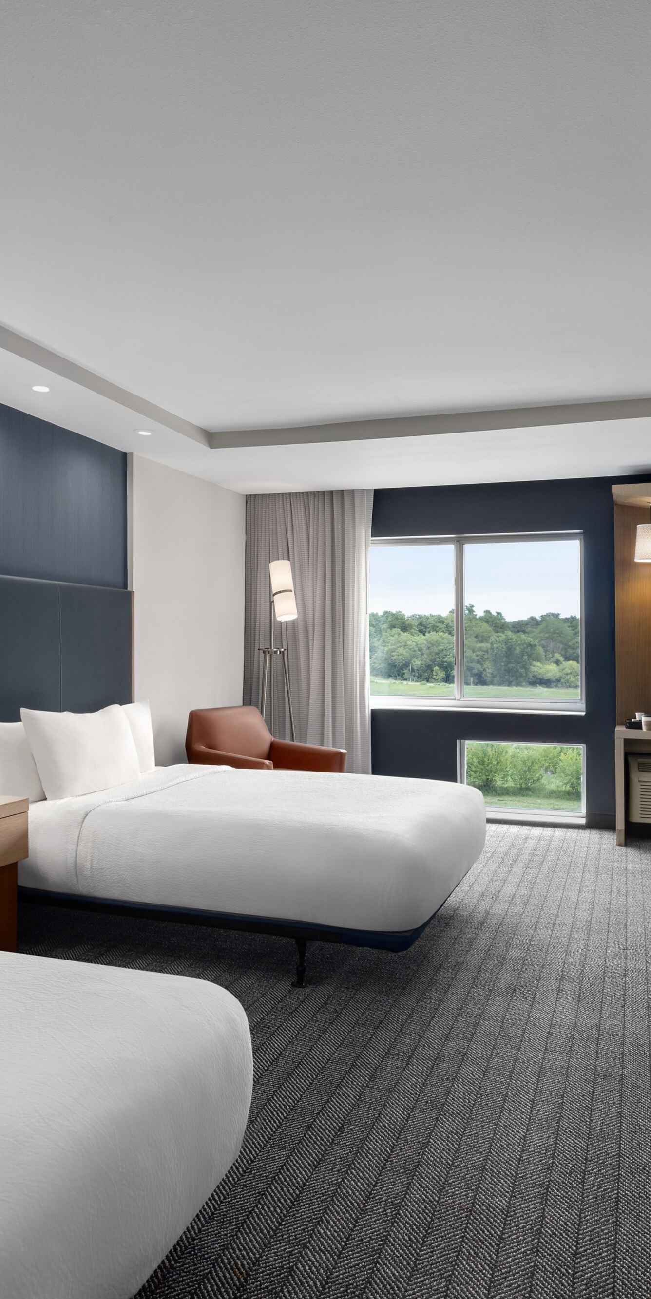 Two queen beds with work desk and window