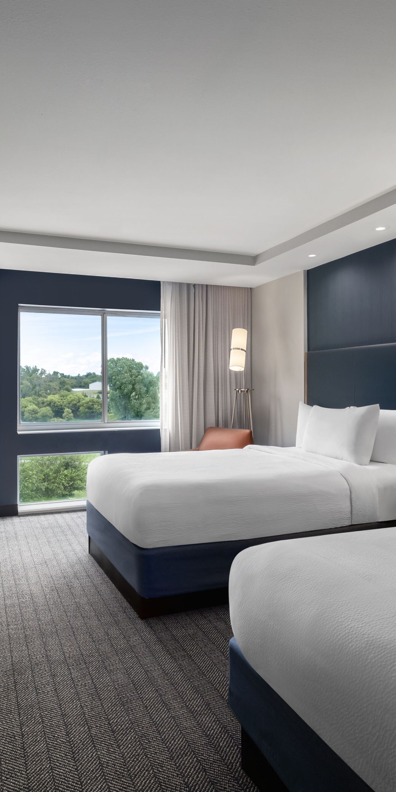 Two queen beds with work desk and window view