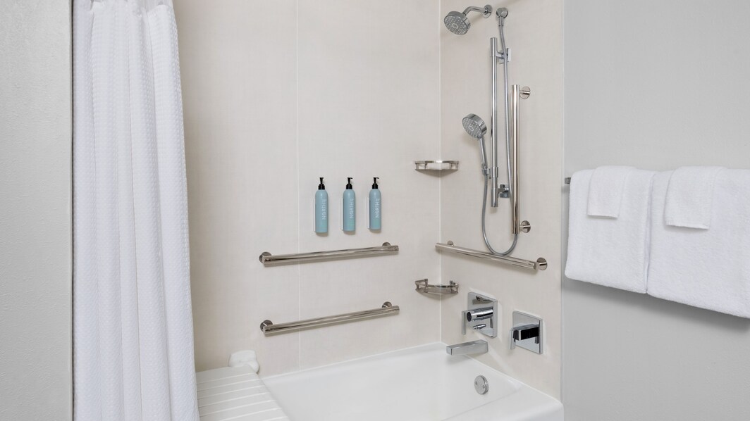 bathtub, handheld combo shower, amenities, towels