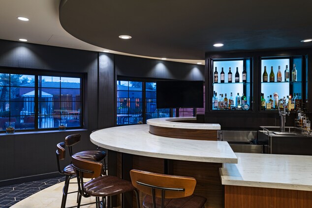 Lobby bar with a flat screen tv and bar stools