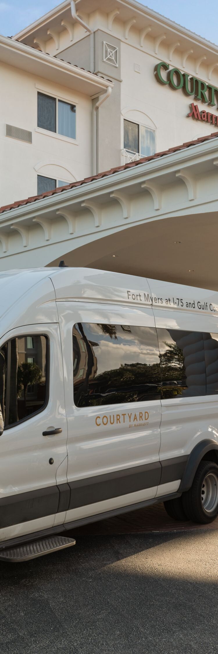 Hotel shuttle van parked at main entrance