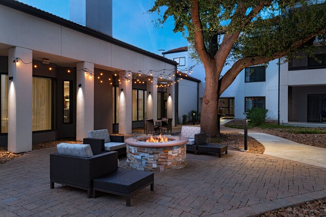 Outdoor area with fire pit, lights, and chairs. 