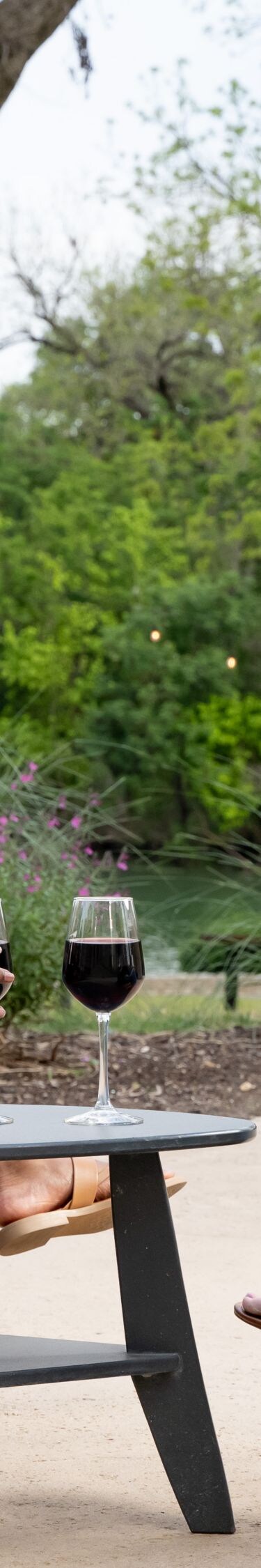 Two women with wine sitting by the river
