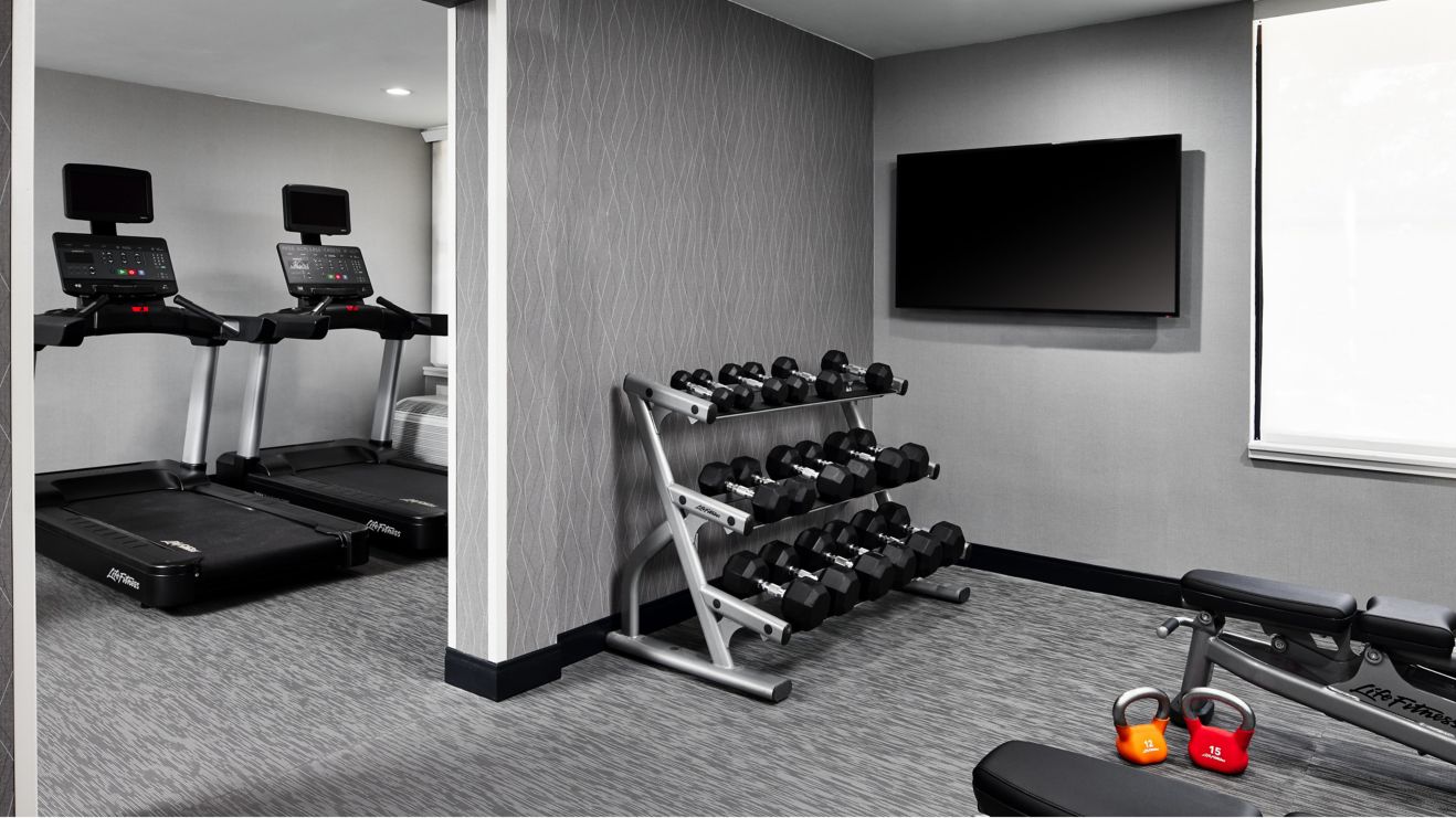fitness center with treadmills, weights and TV