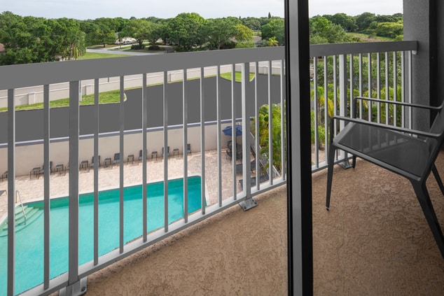Patio balcony with chair overlooking pool