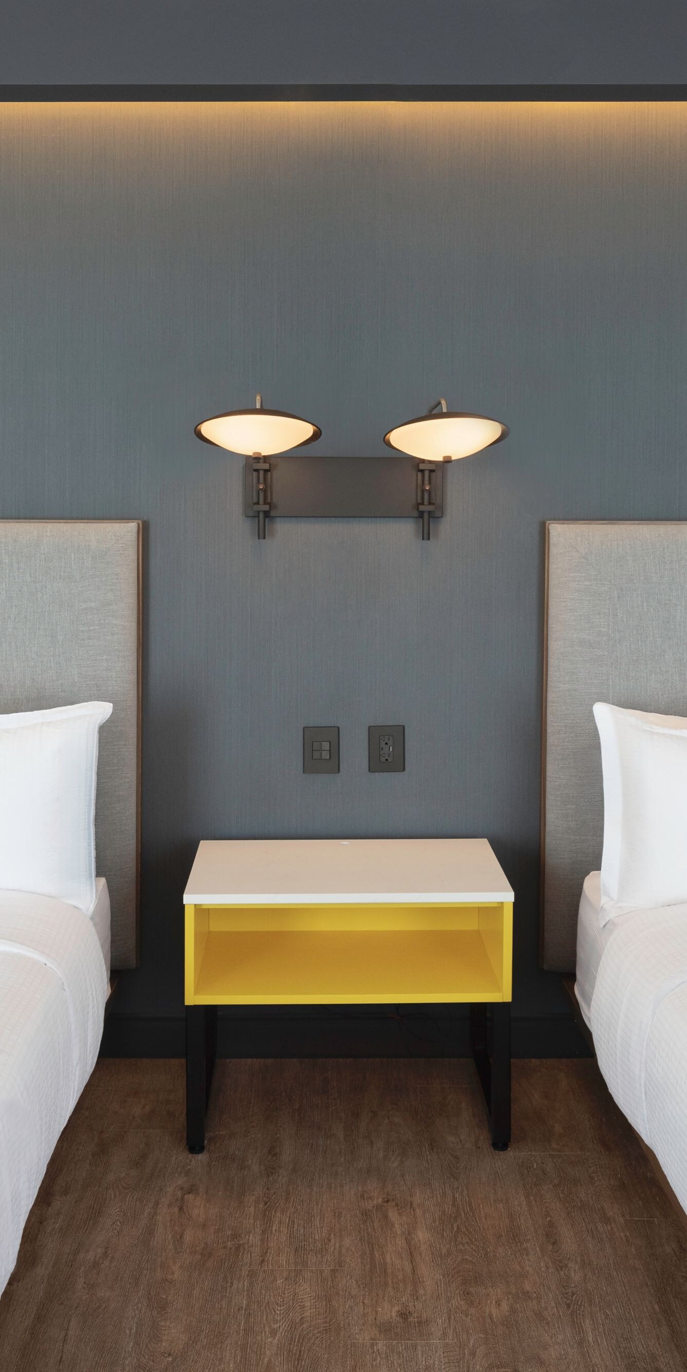 Two queen beds with modern yellow nightstand