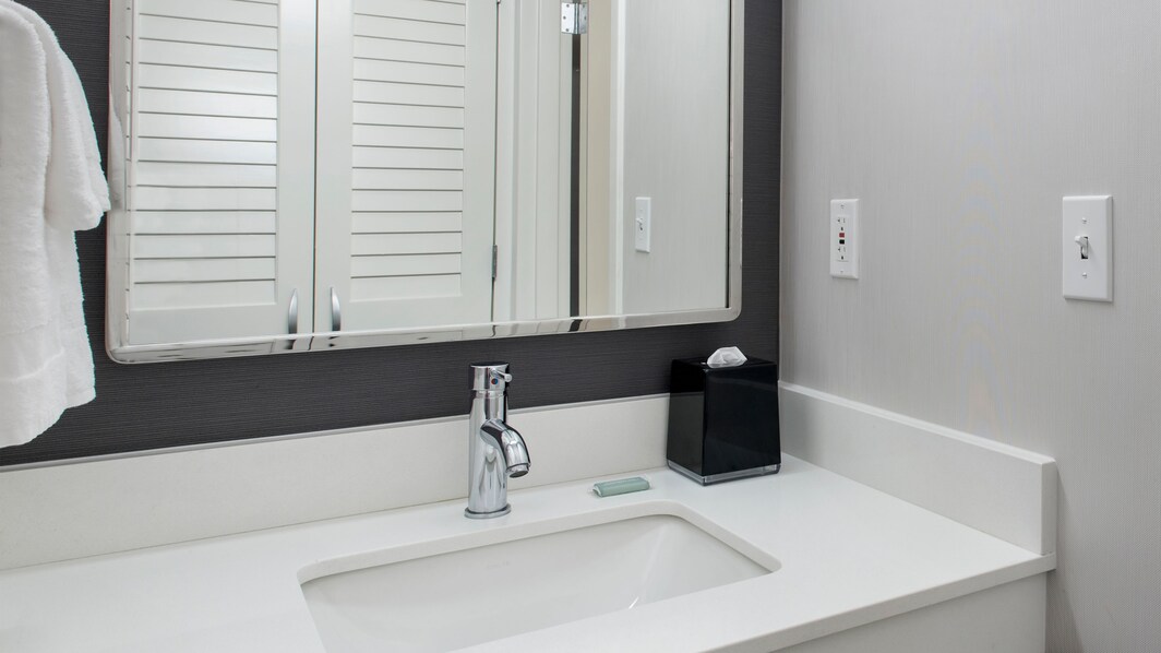 Waschbecken im Bad mit großem Spiegel und Schrankbereich