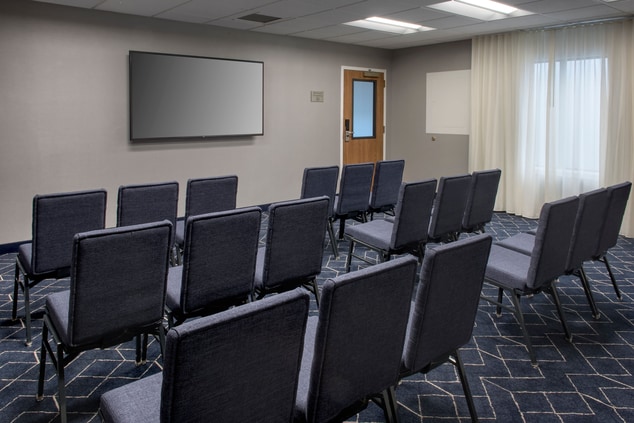 meeting space with chairs facing front of room TV