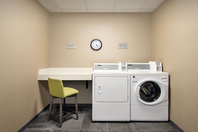 Laundry room with a chair and desk beside the wash