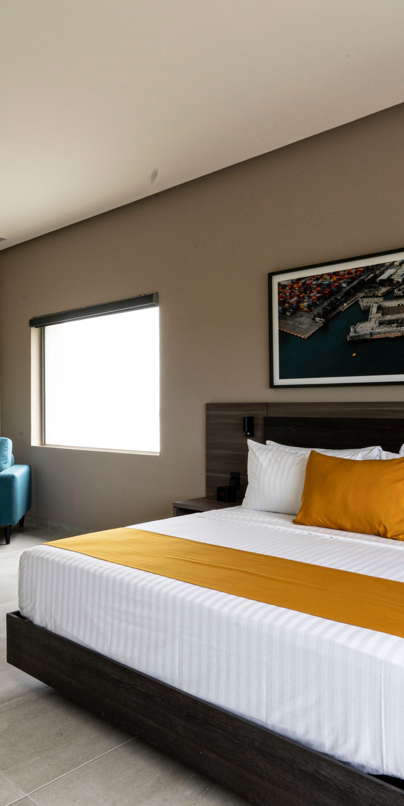 Dormitorio moderno con cama tamaño King, silla y otomana