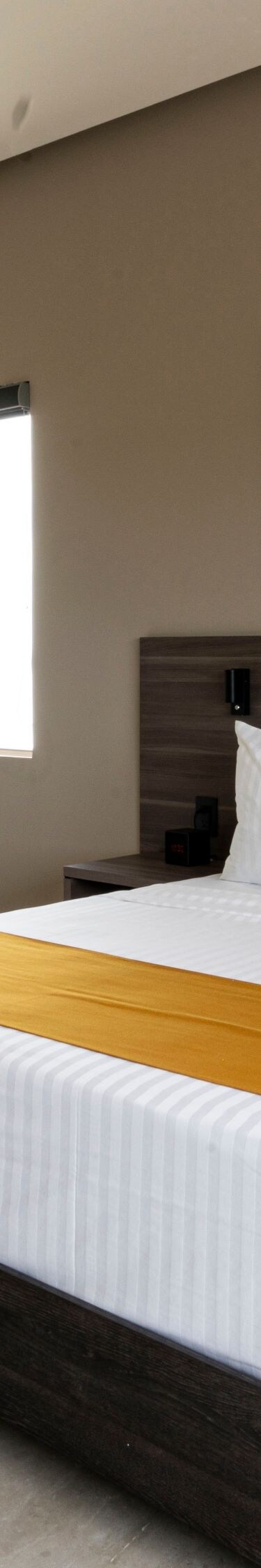 Dormitorio moderno con cama tamaño King, silla y otomana