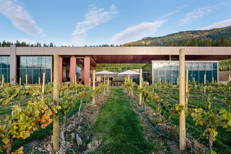 Winery next to tree-covered hills.