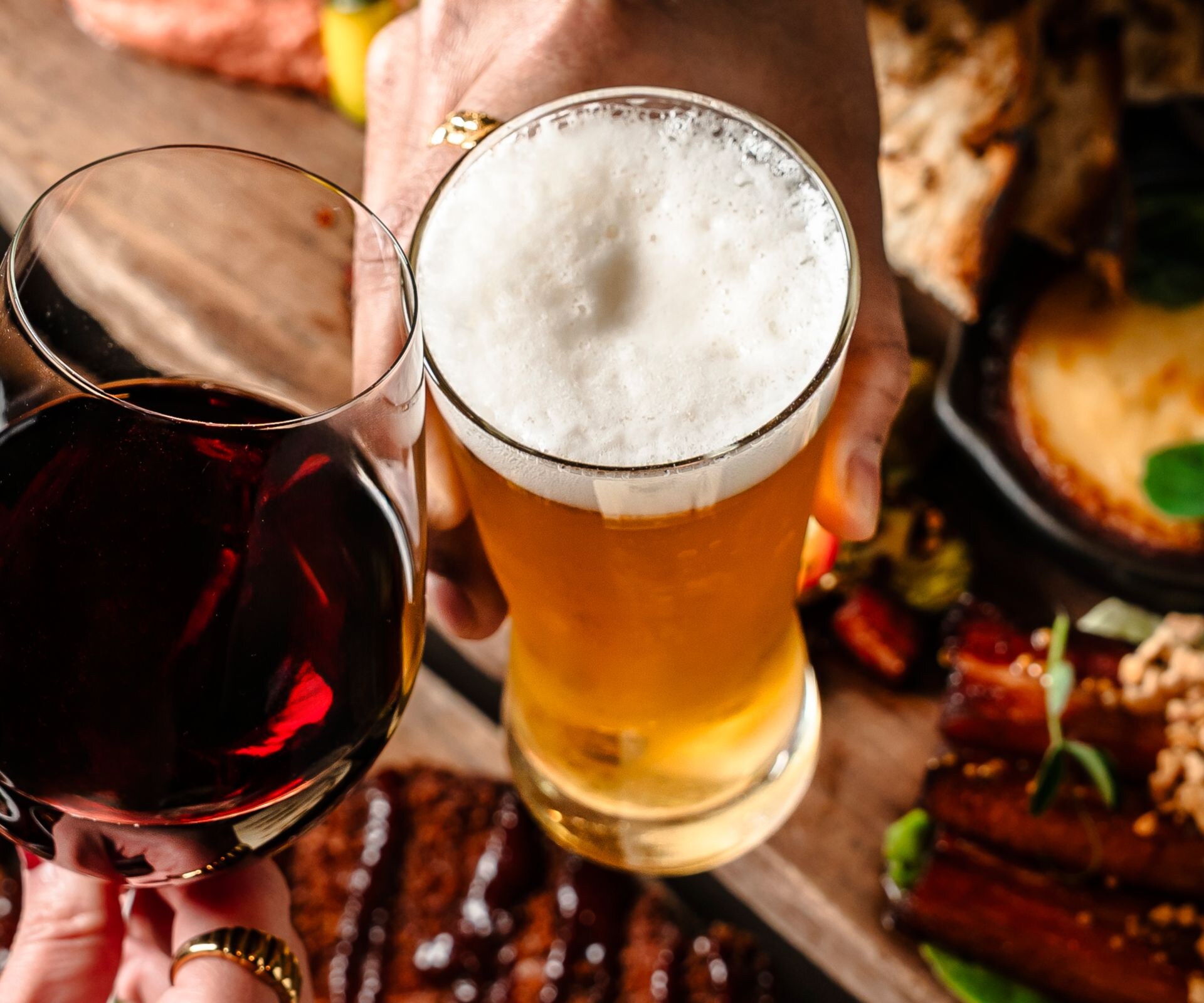 Wine and beer glasses above table of food