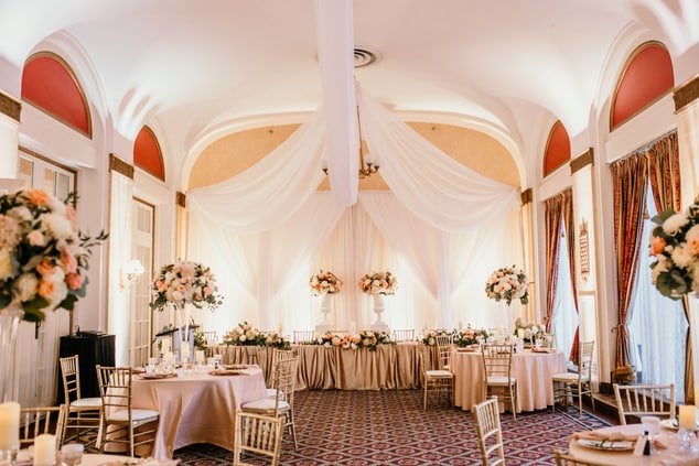 A room set up for a wedding with gold table cloths
