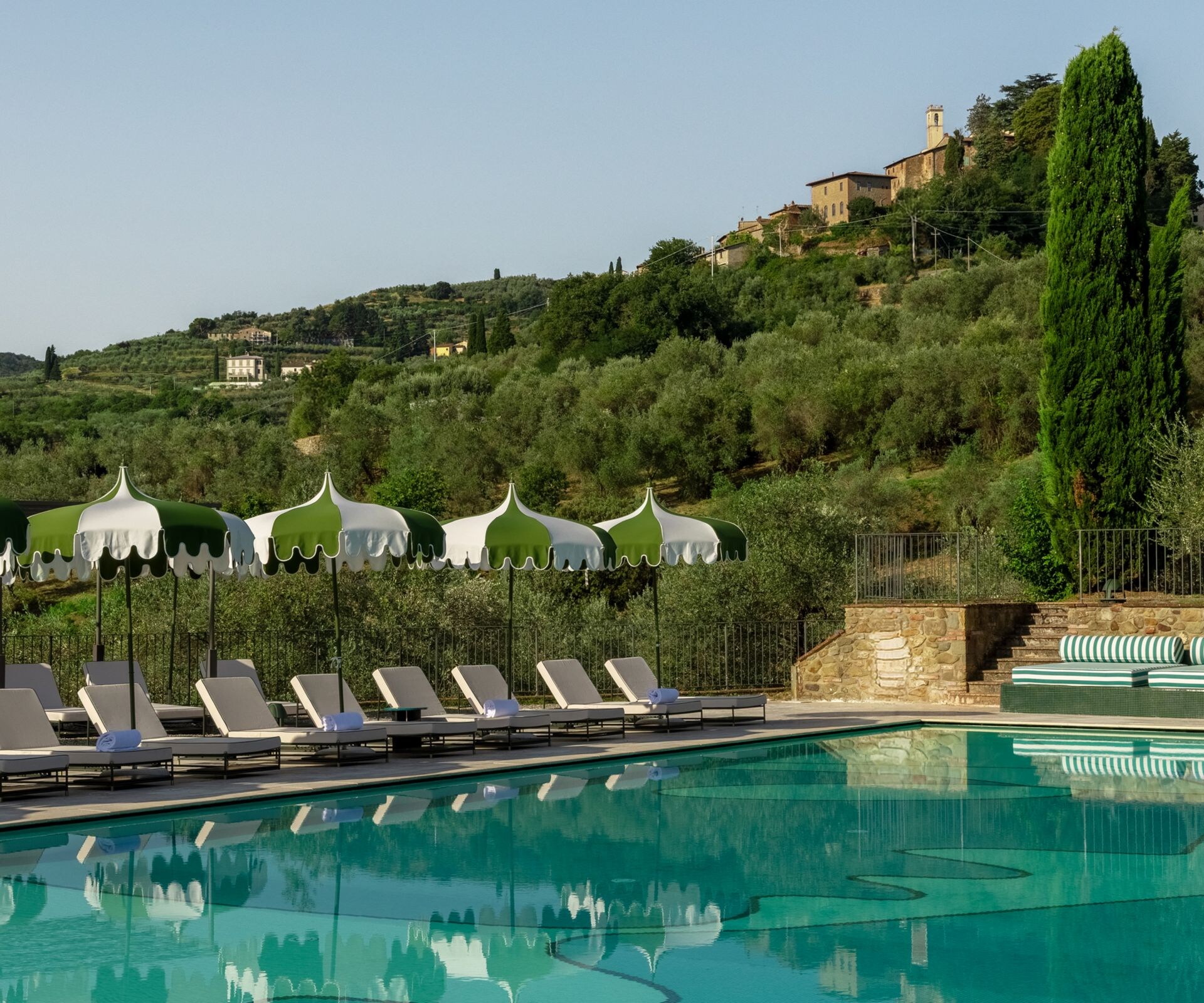 Outdoor pool with sun loungers and hills