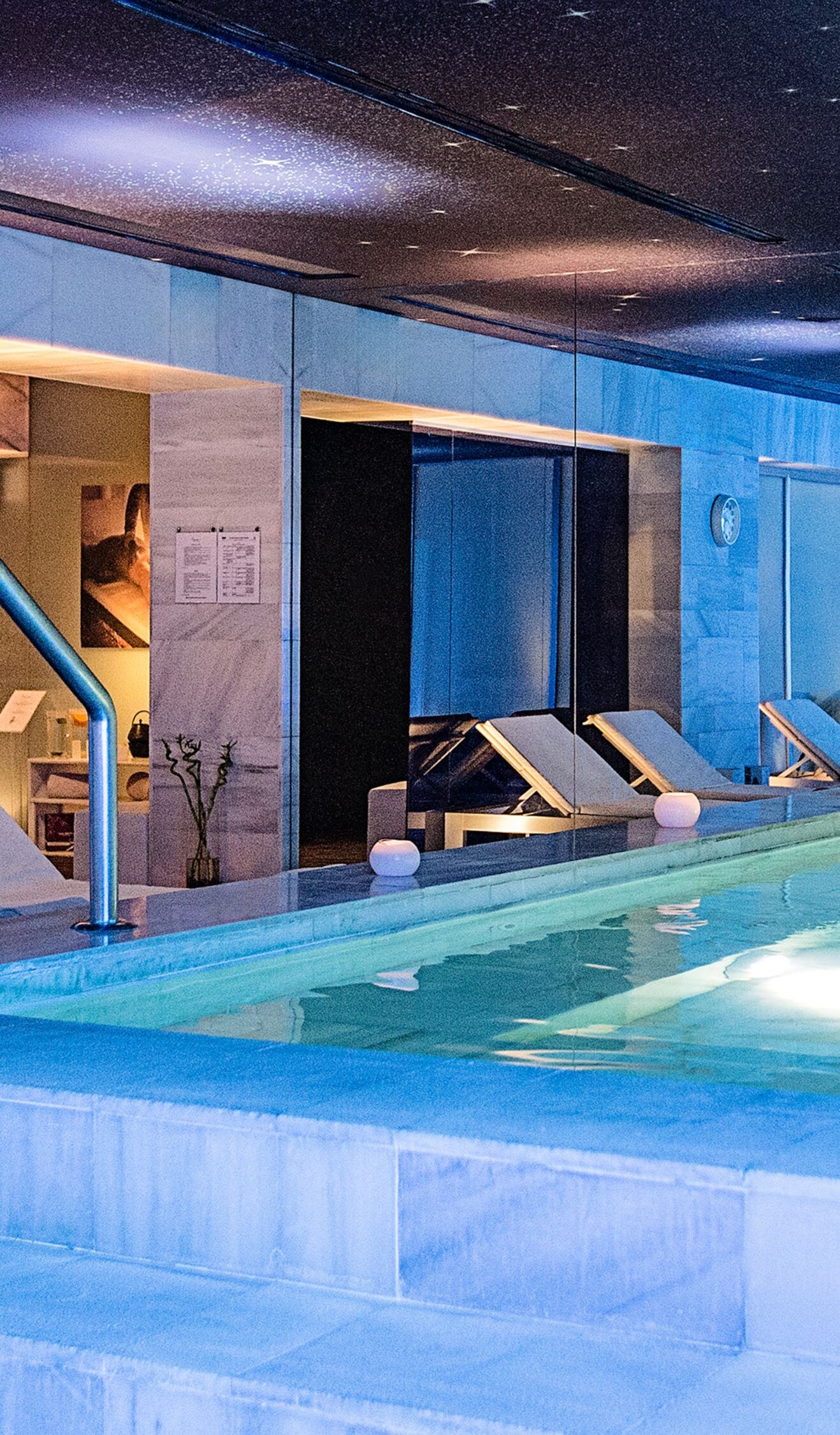 Indoor pool with marble surfaces and loungers