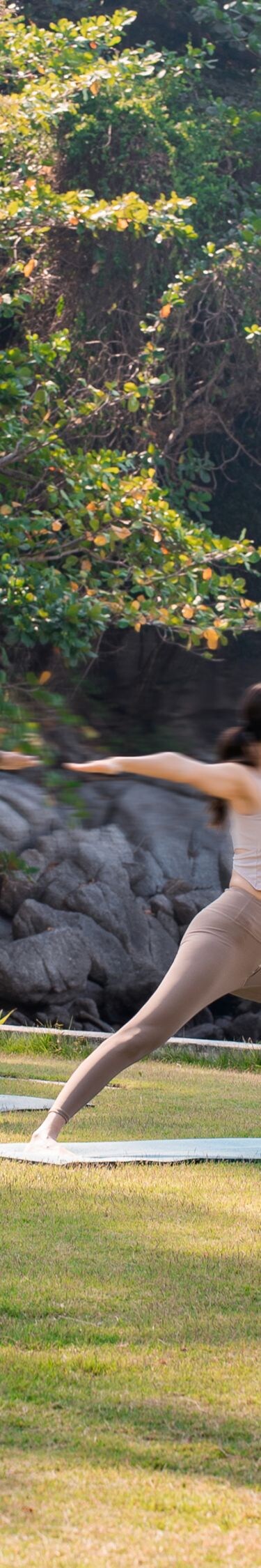 Man and woman doing yoga on the beach