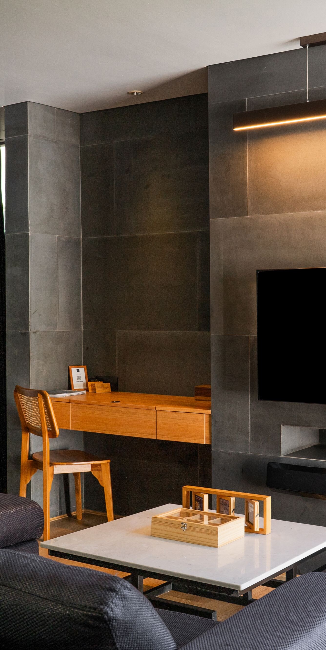 Living room with sofa, desk, and wall-mounted TV
