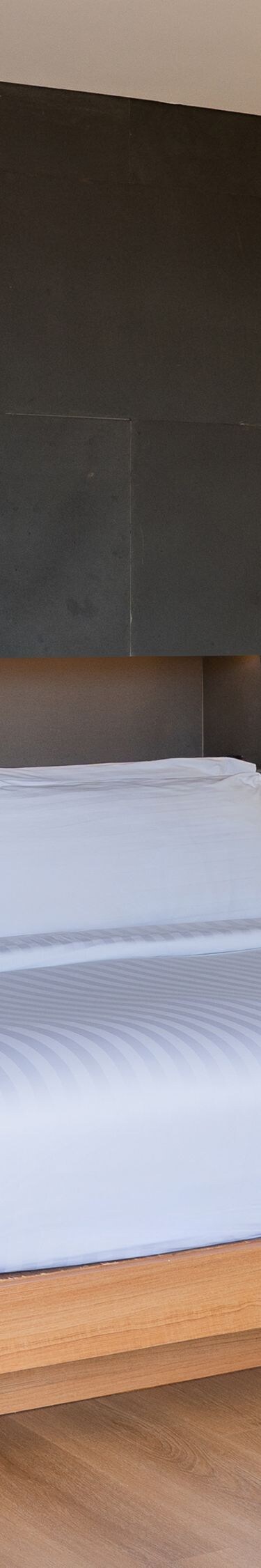 Bedroom with gray accent wall and white bedding