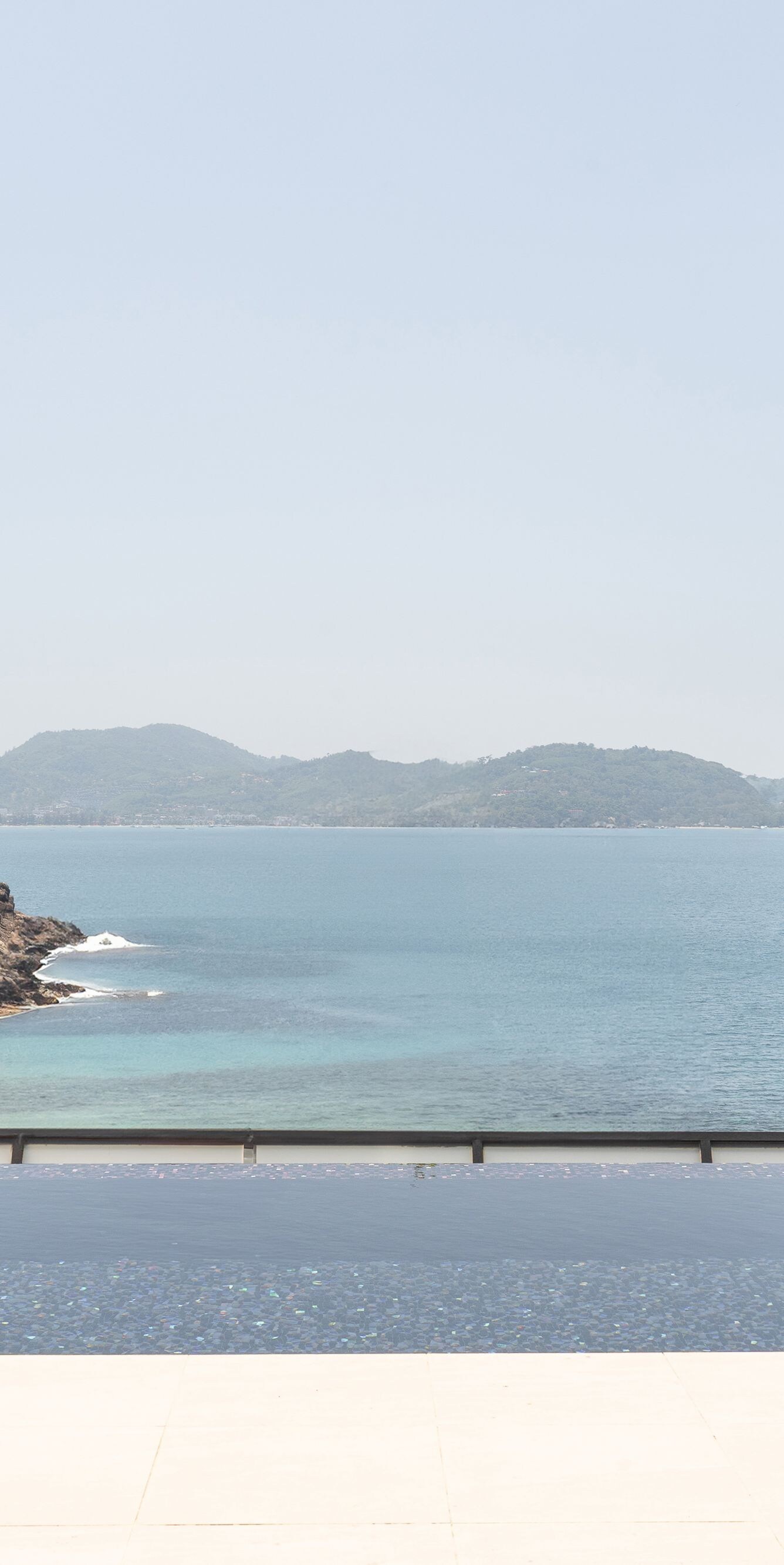 Infinity pool between villa and concrete wall by s
