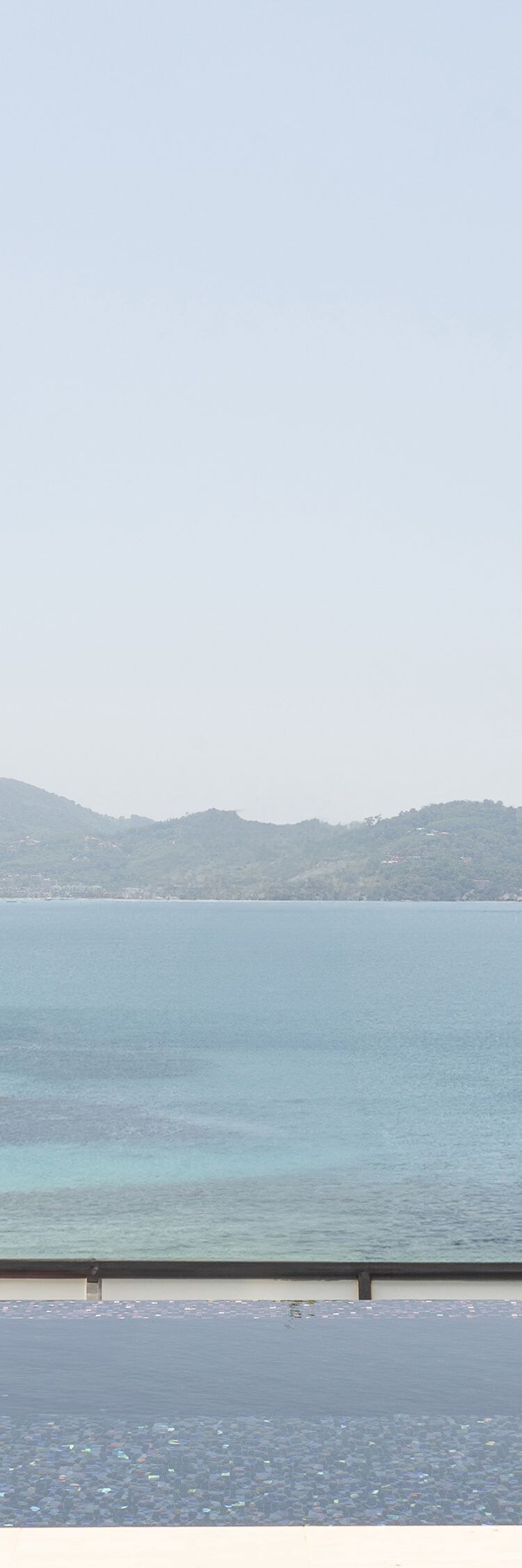 Infinity pool between villa and concrete wall by s