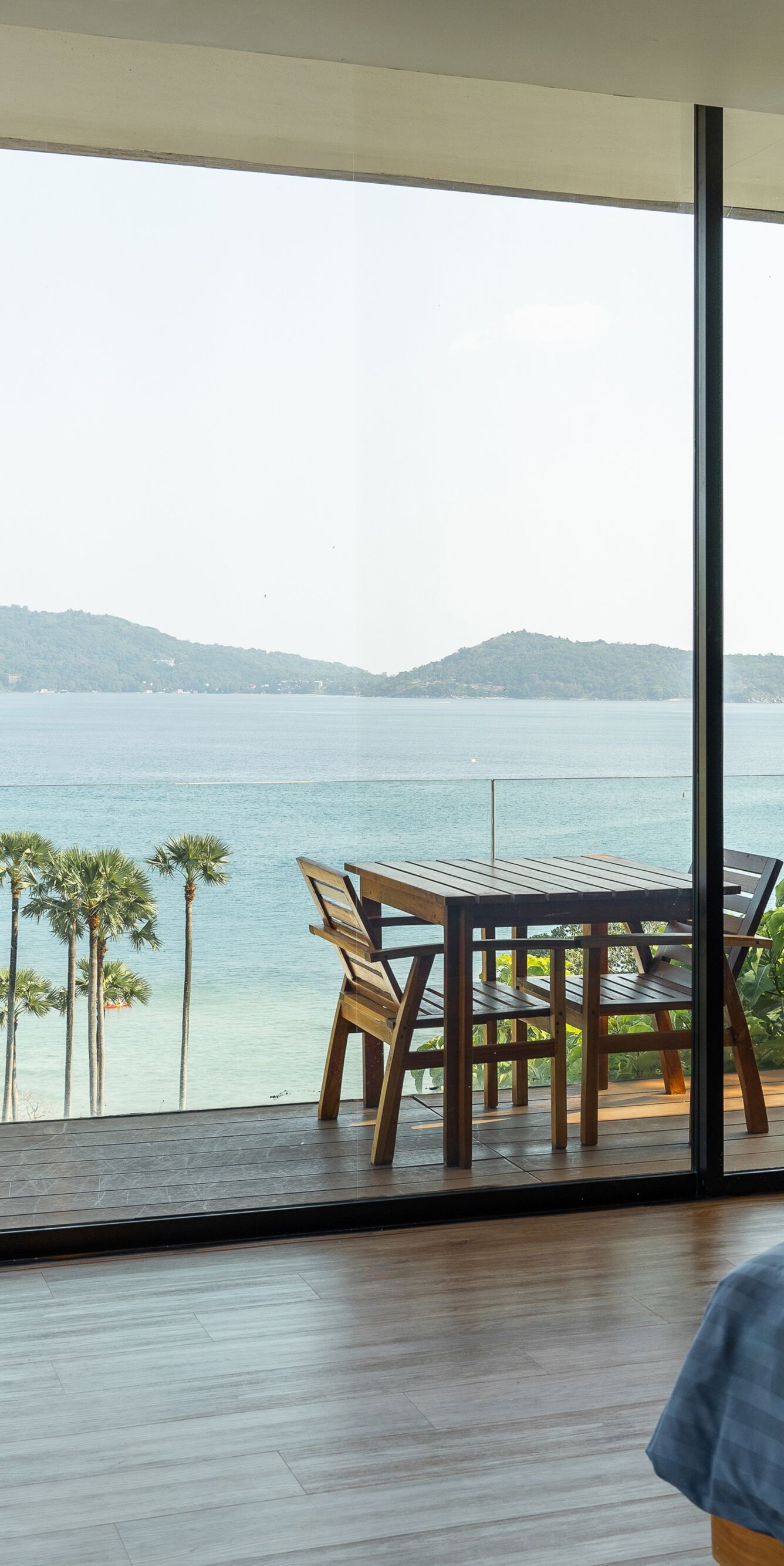 Bedroom with balcony overlooking ocean and palms