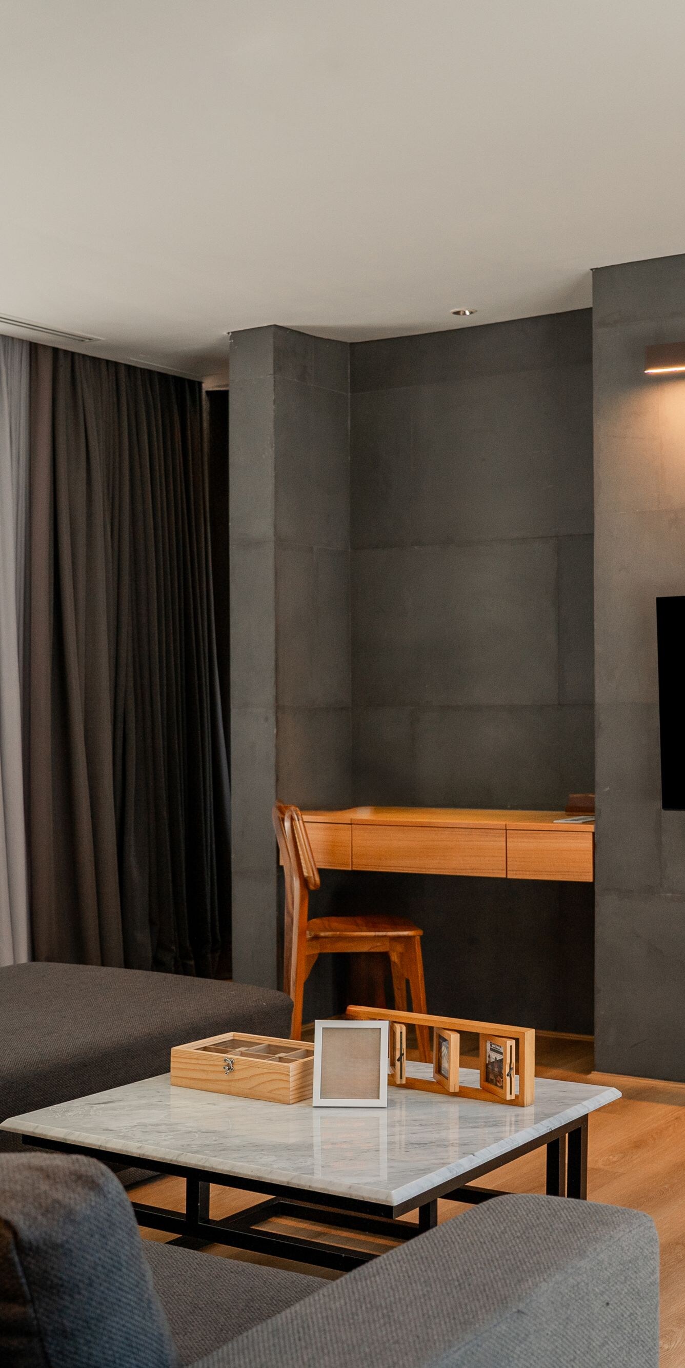 Living room with sofa, desk, and wall-mounted TV