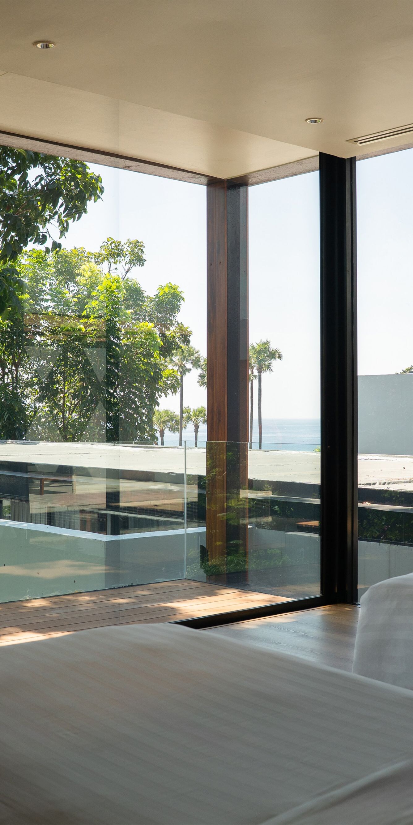 Bedroom with glass walls and view of trees outside