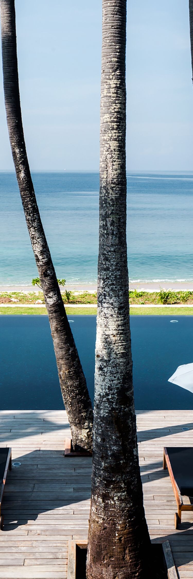 Swimming Pool chairs and umbrellas with beach view