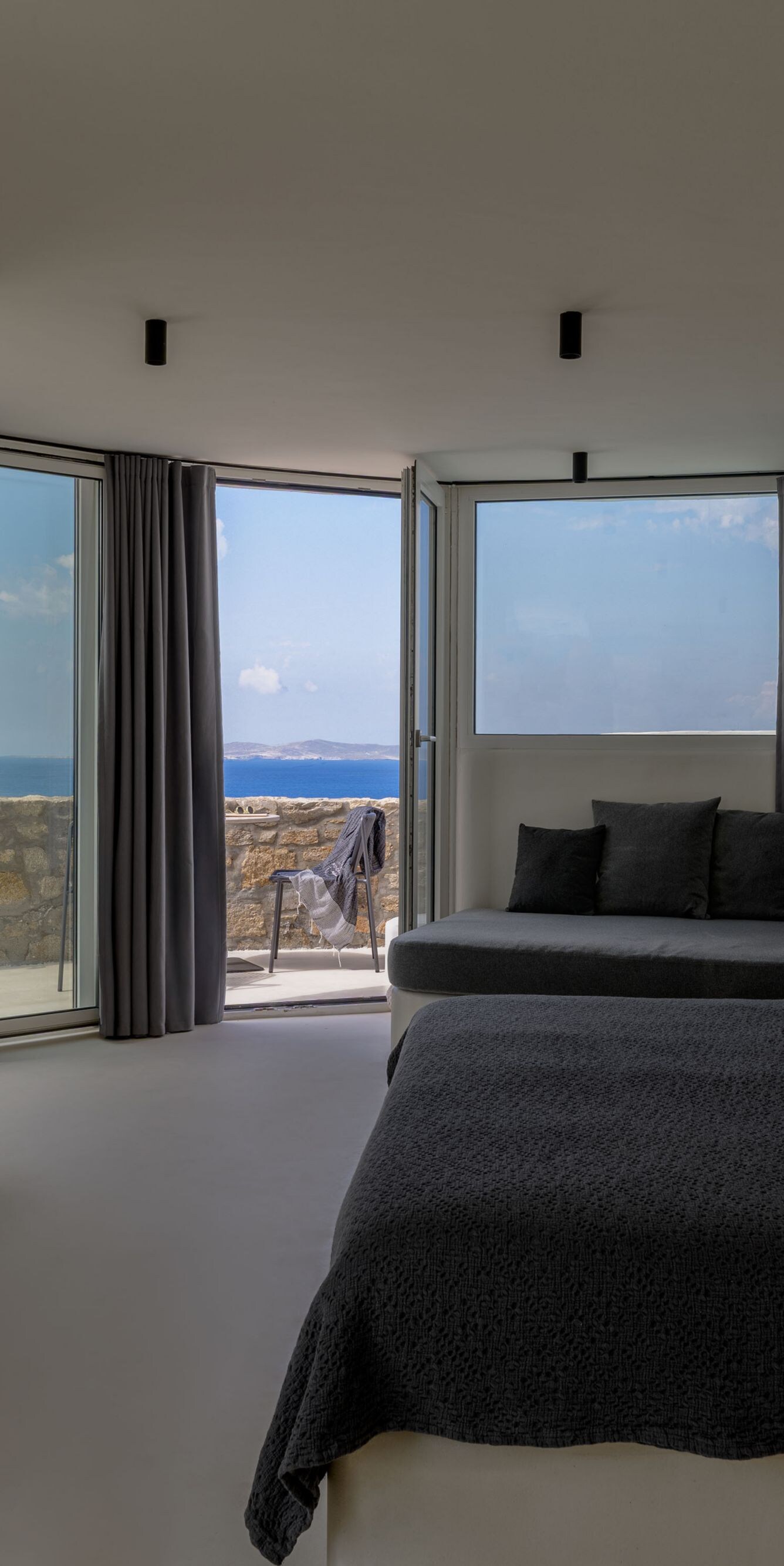 Hotel bedroom with sofa and ocean view balcony