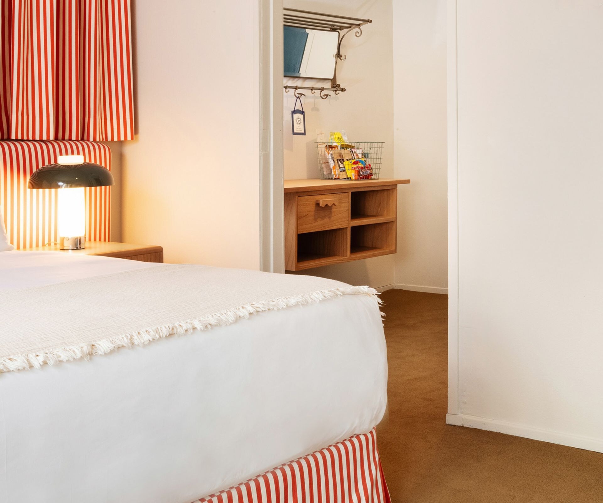 Bedroom with striped bedding and wall mirror