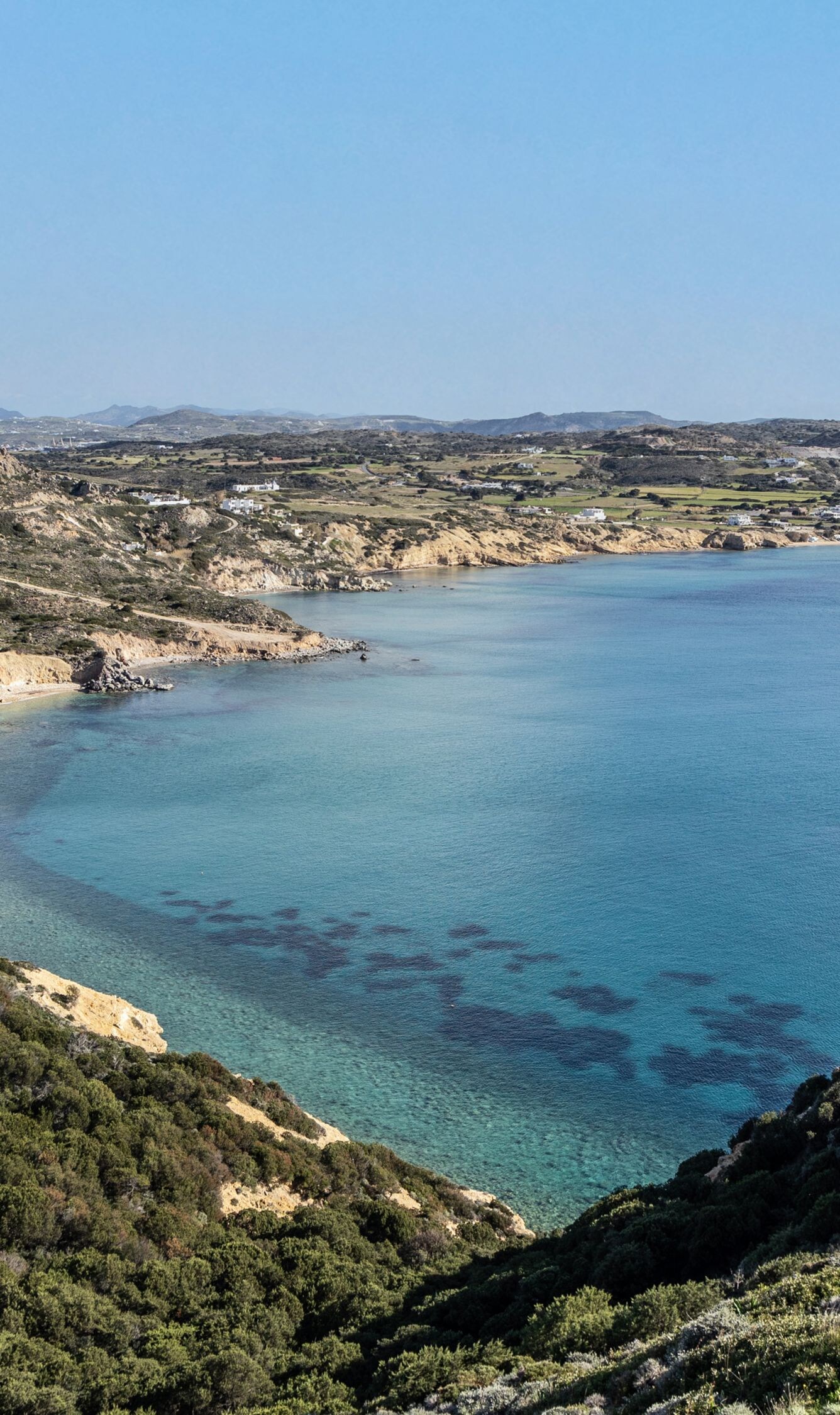 Wide coastal bay with cliffs, hills & blue water