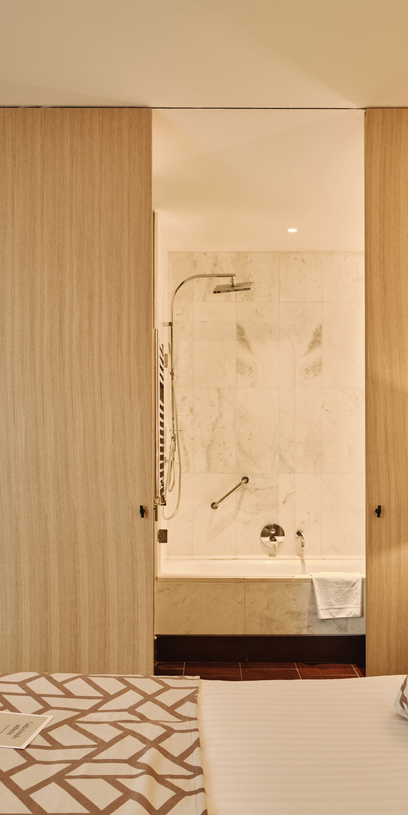 dormitorio con cama y vista al baño abierto