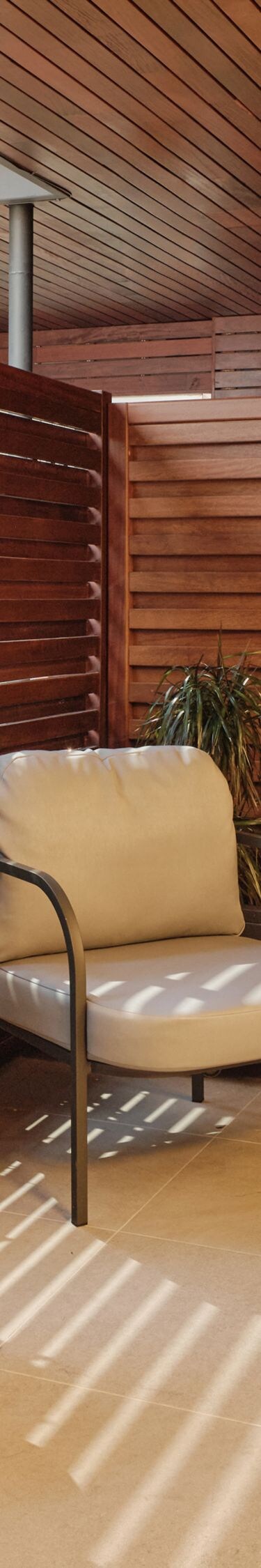 terraza revestida de madera con sillas y una pequeña mesa