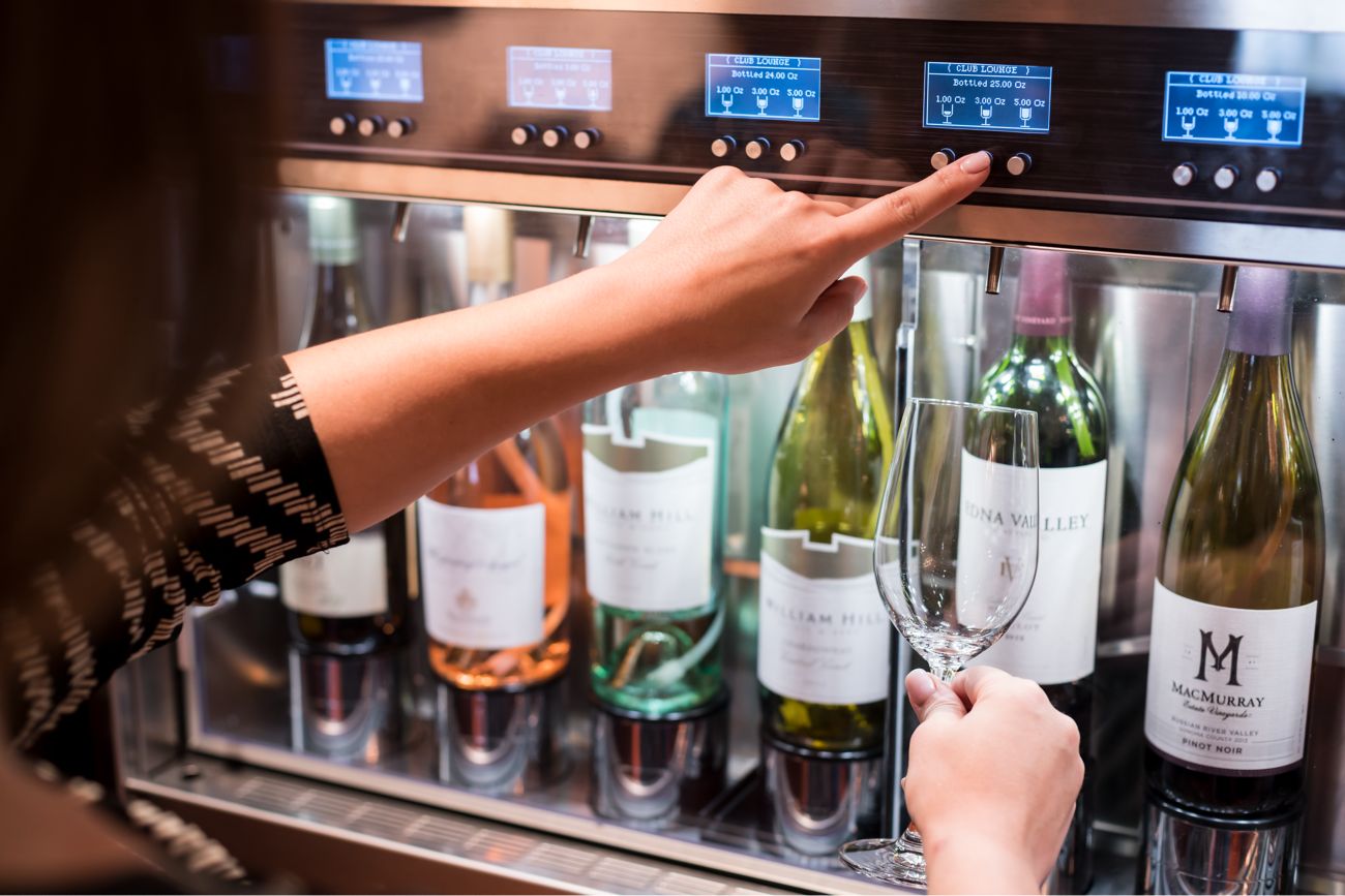 A woman prepares to fill her glass from a wine dispenser