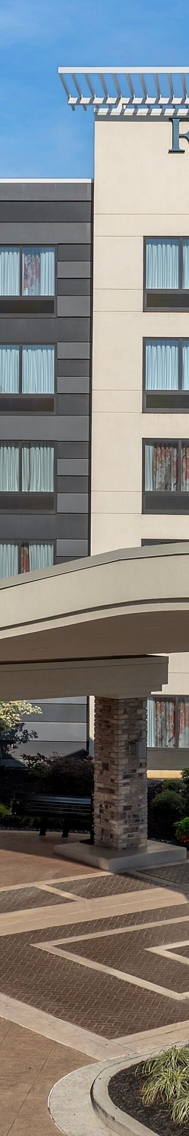 Hotel exterior with main entrance by day