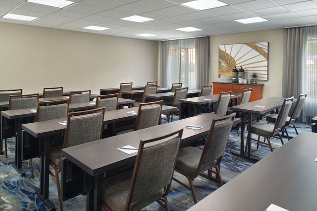 Meeting room with multiple tables and chairs.