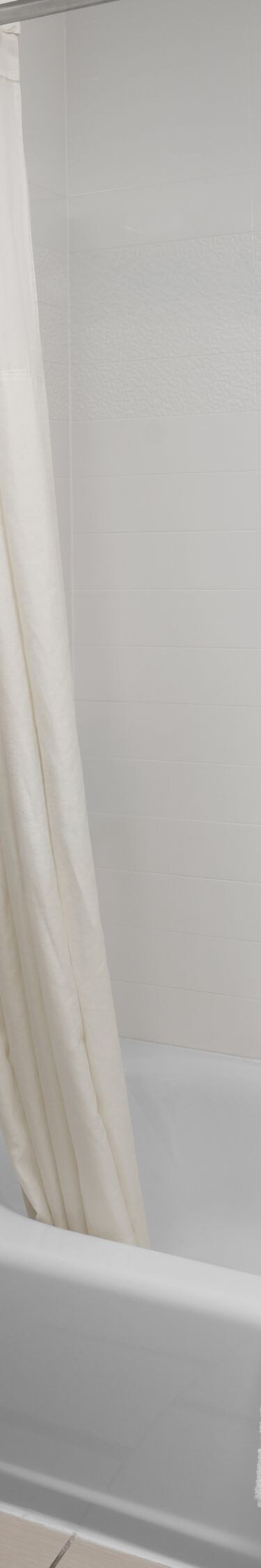 Hotel bathroom with bathtub shower combo and towel
