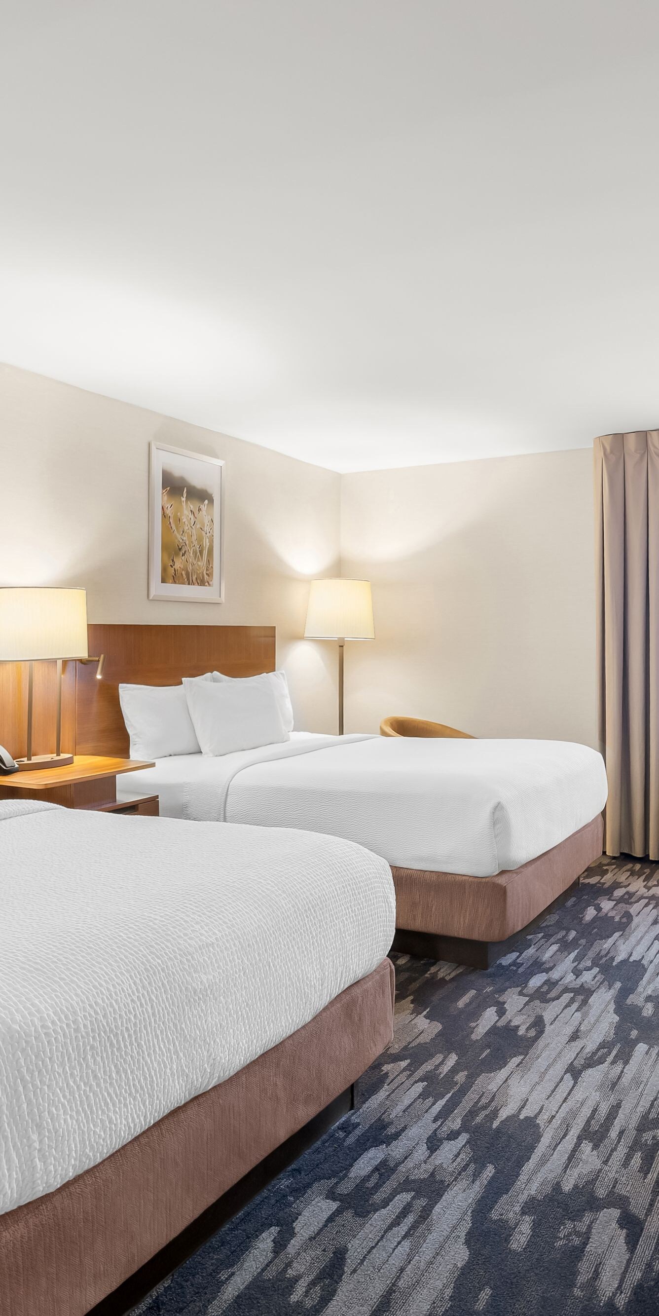 Two queen beds with desk and TV