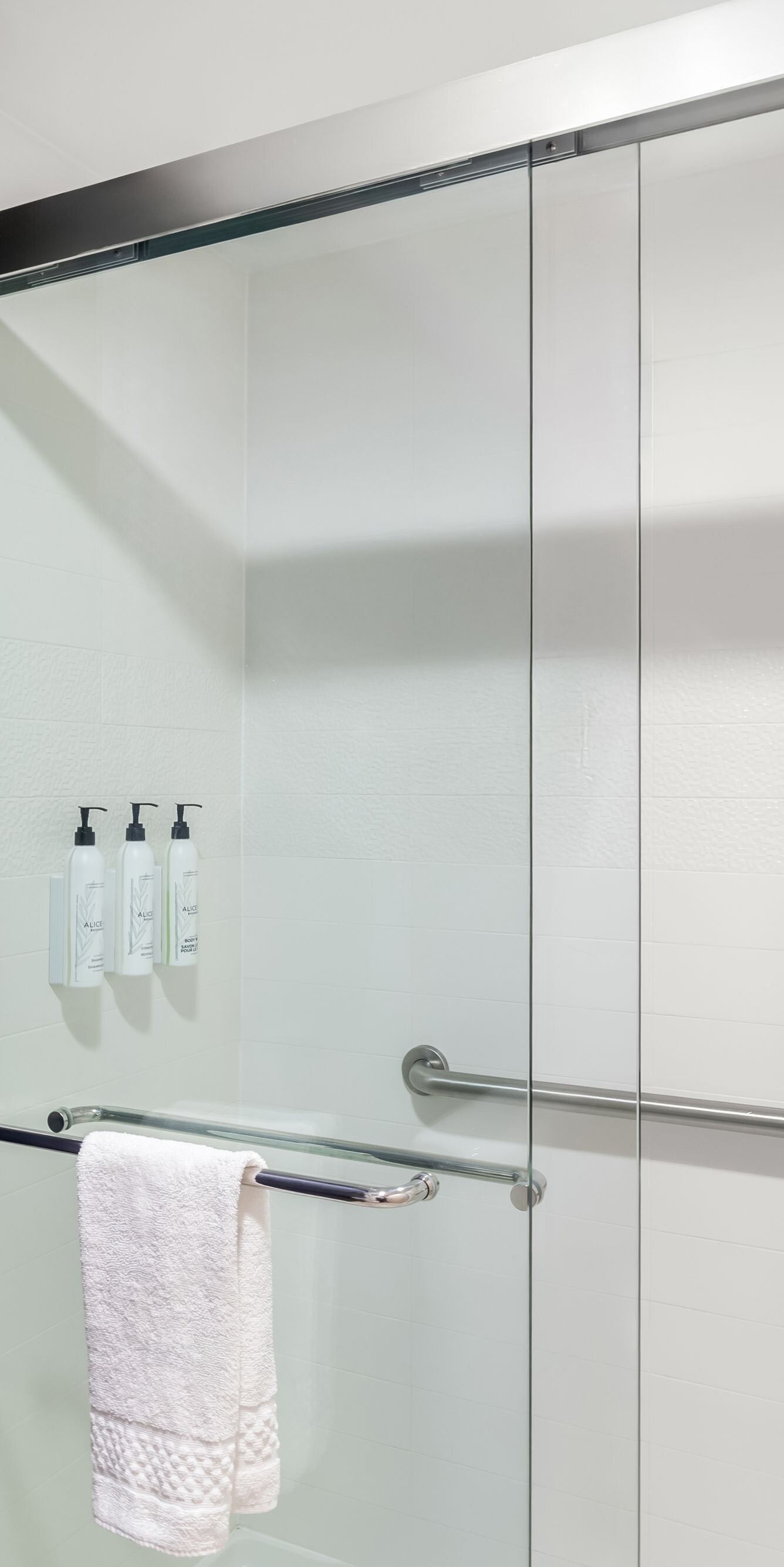 Glass shower with grab bars and curtain