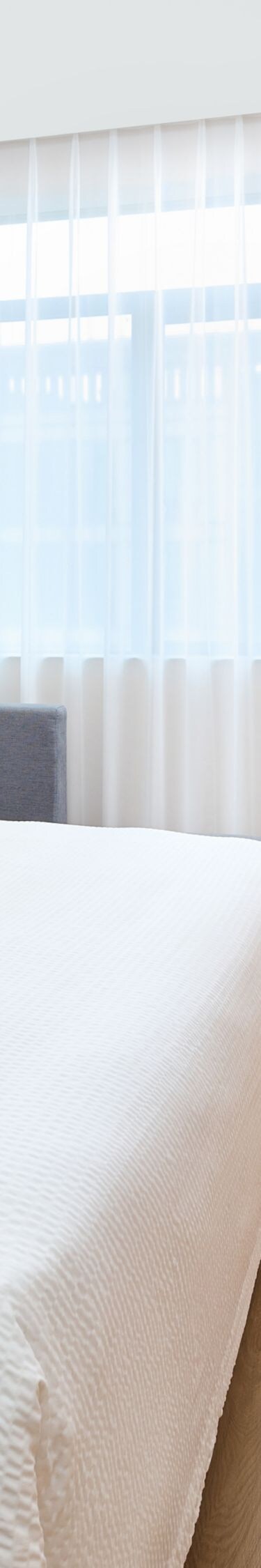 Guest bedroom with bed, TV, bench, table, and sofa
