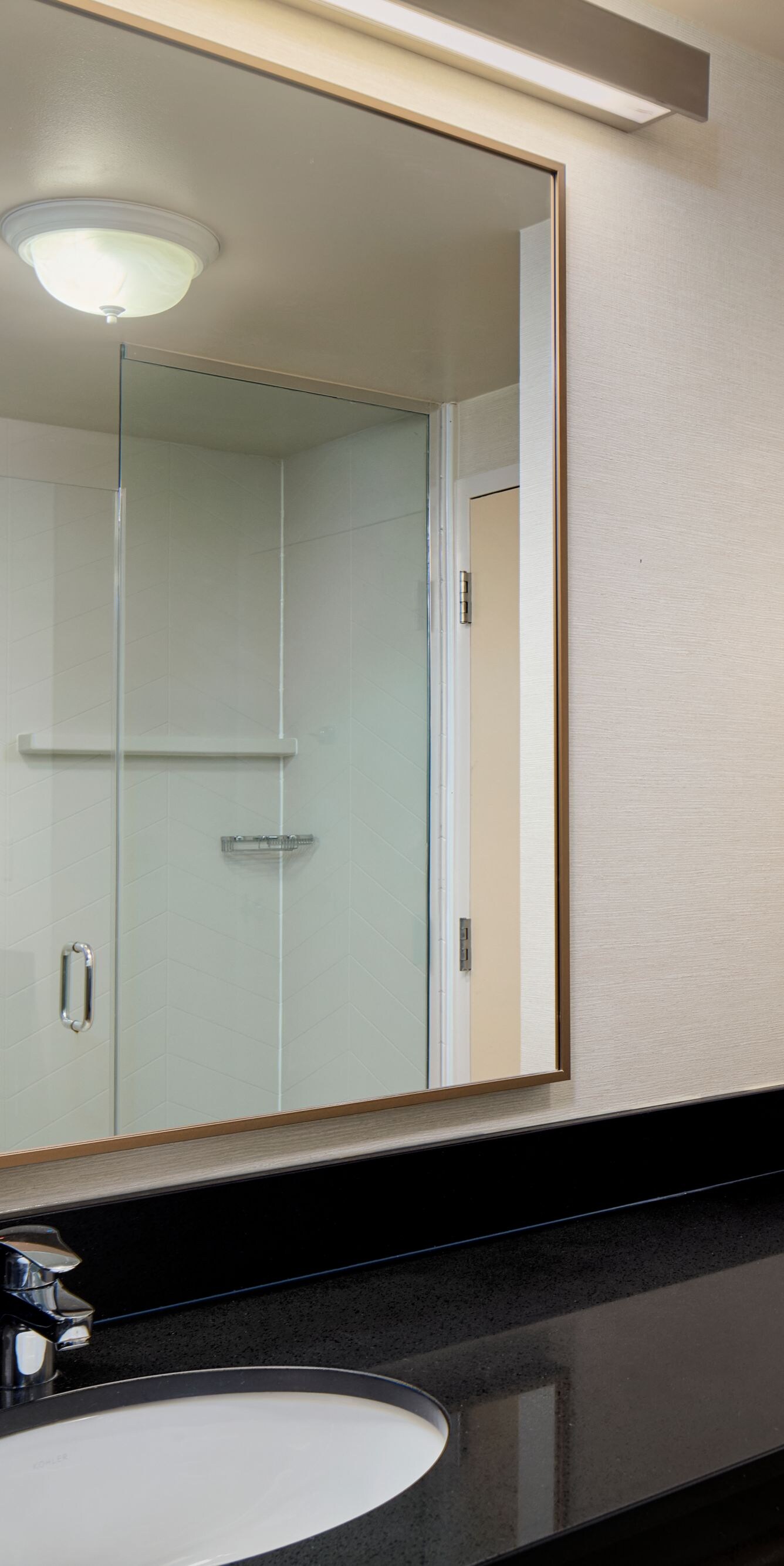 Bathroom vanity with mirror and glass shower door